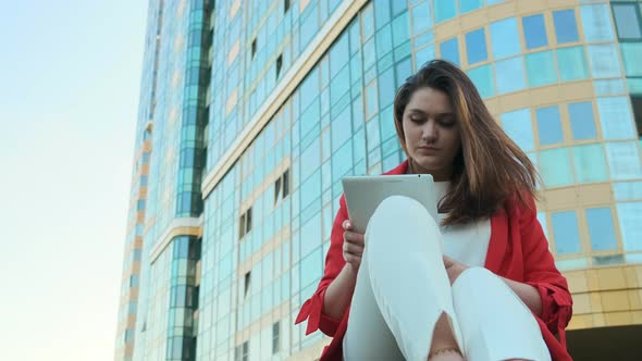 Business Woman Sitting on the Lawn, Against the Background