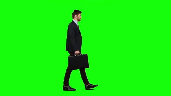 Man Holds a Briefcase in His Hand, He Rushes Over It. Green Screen