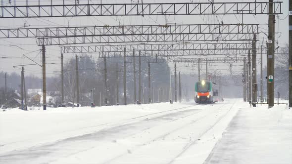 Intercity Modern Electric Train Rides on Snowcovered Rails