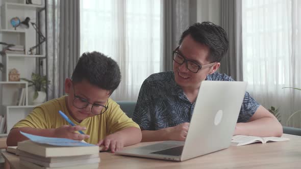 Caring Father Help Son Learn Online From Home. Homeschooling Conducted By Parent