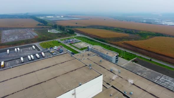 Modern big plant in green field. Huge industrial territory from above.