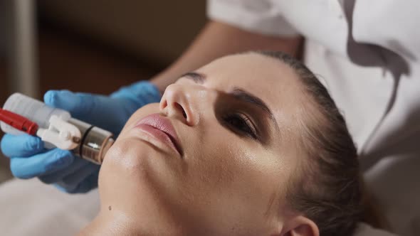 Beautician Preparing Woman's Face for a Noninjection Mesotherapy Treatment