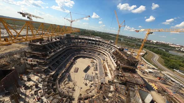 Stadium with Cranes and Workers at Construction Site