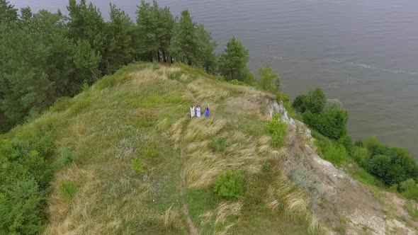 Aerial View at Fun Girlfriends Wearing Long Summer Fashion Dress Walking Near Lake or River