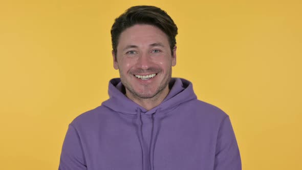 Man Smiling at Camera Yellow Background