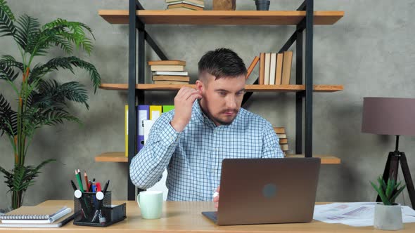 Businessman looking at laptop puts on earphones connect online videocall meeting