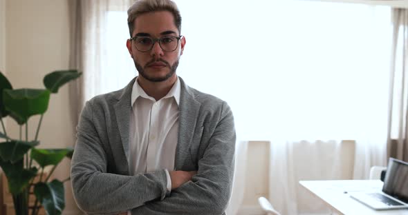 Young man looking on camera inside modern office