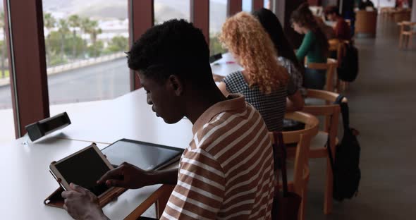 Group of young students learing together inside school library