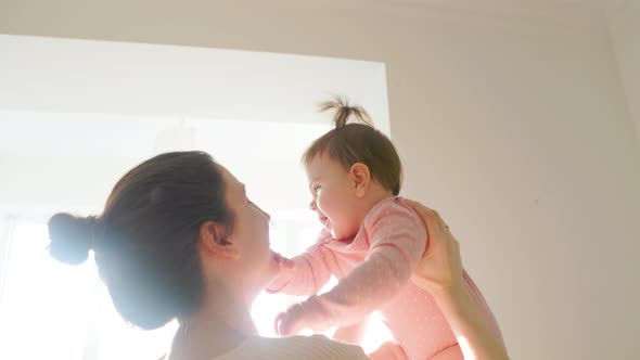 a Cute Baby Girl is Happy Benevolent Playing with Her Mother