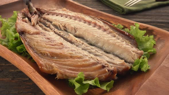 Closeup of a Tasty Grilled White Mackerel Fish on Plate with Salad Leaves Plate