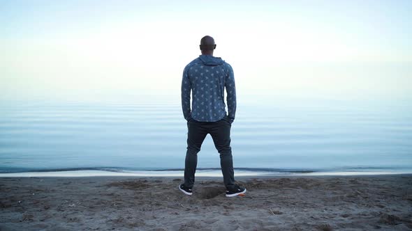 Man staring out across a beautiful lake during sunset