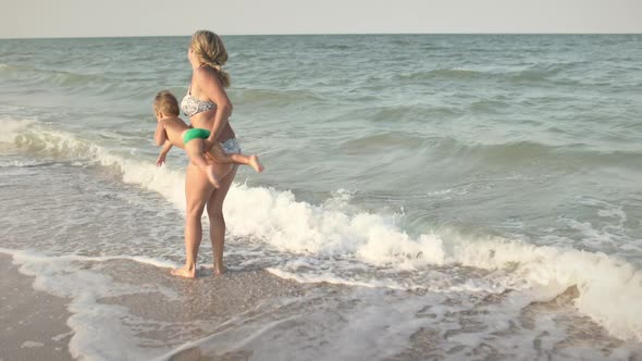 Mom Throws Her Son Up Over the Sea on Summer Vacation Under the Warm Sun