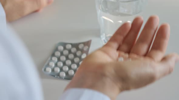 White Small Pills in Hand of the Patient