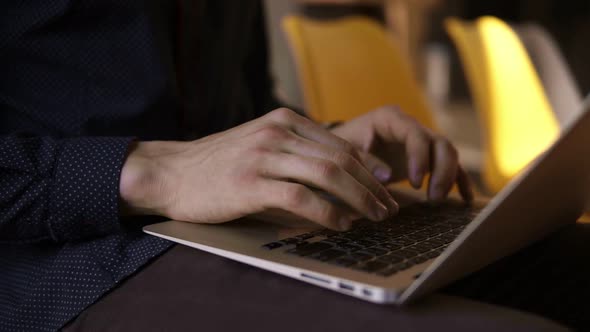 Male Hands Typing Something on a Laptop Keyboard