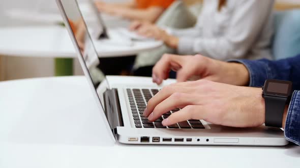 Group of executives working over electronic devices at desk