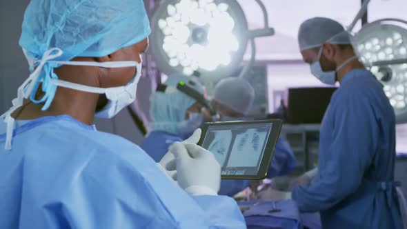 Close-up of African American male surgeon using digital tablet in operation theater at hospital a