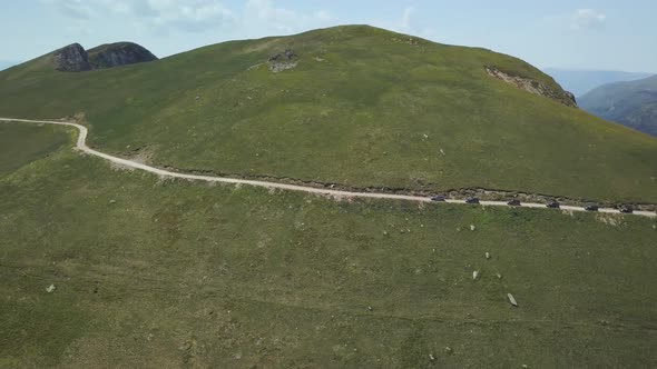 Aerial view of a group of cars rides along the mountains Kolasin in spring in Montenegro