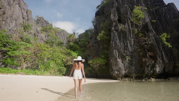 Woman Walking Along Sunlit Hidden Beach