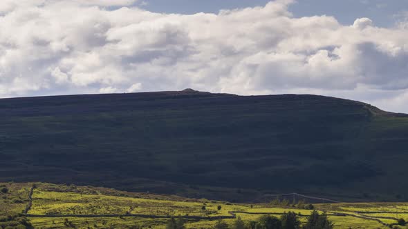 Time lapse of rural hillside landscape on a sunny summer day with passing clouds in Ireland. alt