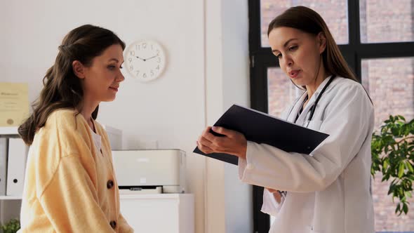 Doctor with Clipboard and Woman at Hospital