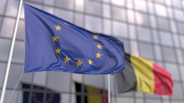 Waving Flags of the EU and Belgium in Front of a Modern Skyscraper