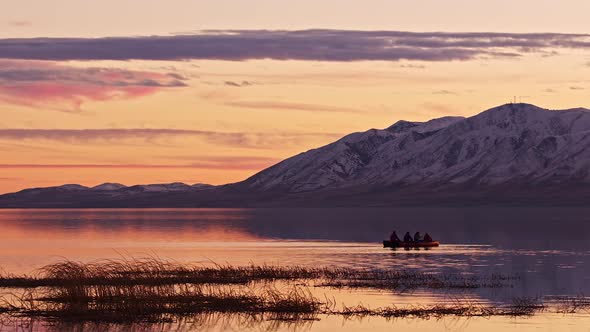 Colorful sunset over Utah Lake with canoes floating on the water