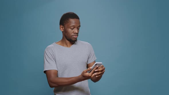 Cheerful Man Reading Good News and Achievement on Smartphone