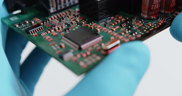 Technician Examines the Chips of Electronic Device
