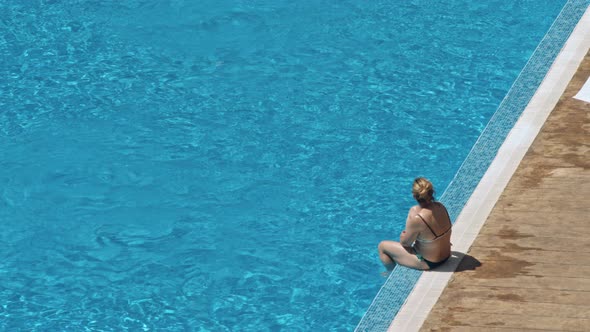 Beautiful Young Women Relaxing on the Deck Near the Pool