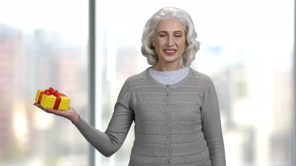 Smiling Mature Woman Posing with Gift Box.