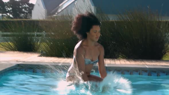 Beautiful woman jumping in swimming pool on a sunny day 4k