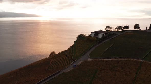 Jib down of house at hillside against the backdrop of a beautiful lake at sunset