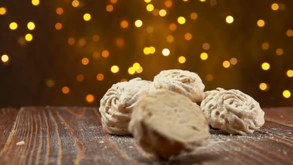 Meringue Cookies Are Falling on a Background of the Festive Christmas Lights