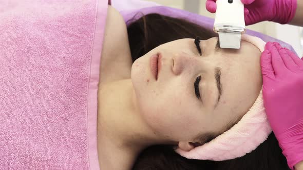Ultrasonic scrabbing. Young woman receiving ultrasound cavitation facial peeling cleansing.