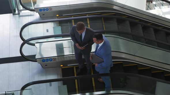 Businessmen on an escalator in a modern building