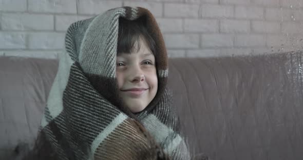 Child in cold room by window. 