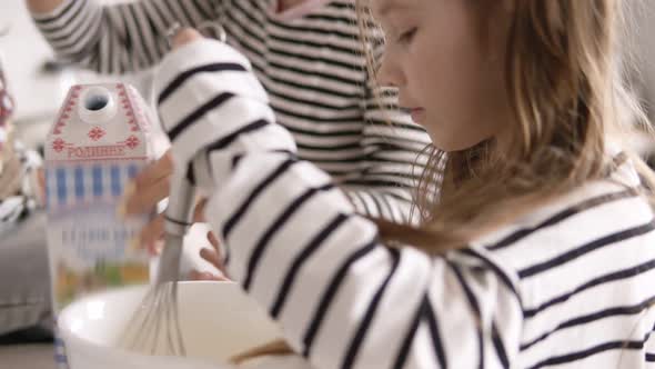 Daughter is Kneading the Dough with Her Mother and Sister on the Kitchen