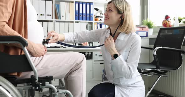 Woman Listens to Belly with Stethoscope to Pregnant Woman in Wheelchair