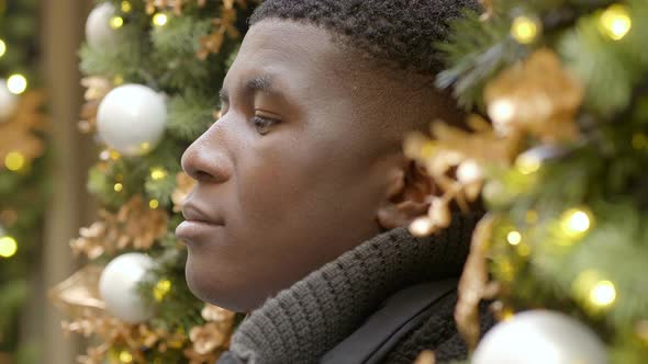 thoughtful young black man at christmas time lost in his thoughts