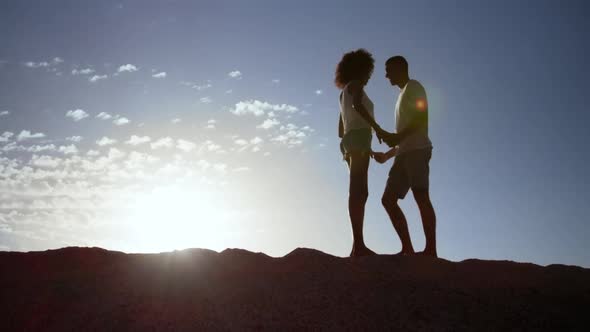 Couple standing on rock at beach 4k