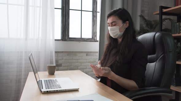 Young Woman Applying Sanitizer Spray Rubbing Hands Before Distance Computer Work From Home Office on