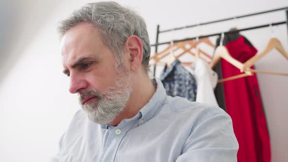 Satisfyied Gray Haired Bearded Man Working on the Computer in His Bedroom  Close Up Shot