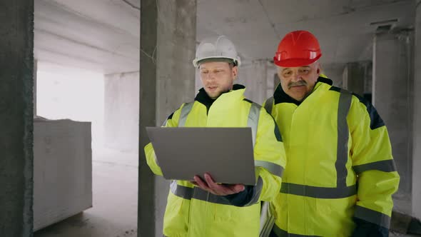 Foreman and Civil Engineer are Walking in Underconstruction Building Portrait of Two Builders