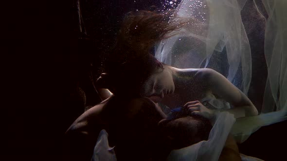 Sensual Loving Pair Inside Water in Darkness and Depth of Sea or Ocean, Underwater Shot