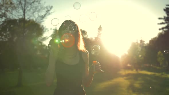 Young Attractive Handsome Pretty Adult Girl Playing with Soap Bubbles, Outdoor Having Fun