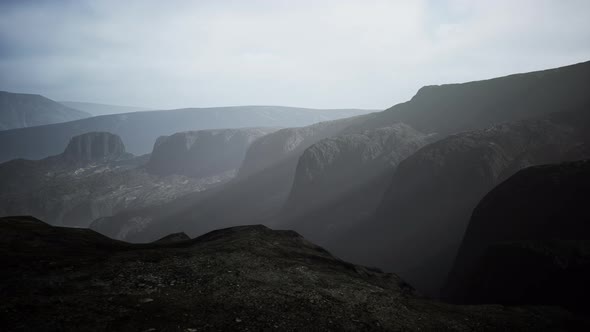 Dark Atmospheric Landscape with High Black Mountain Top in Fog