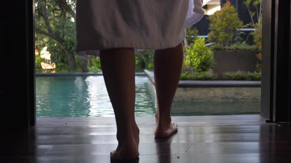Low Shot of Female Walking Towards the Swimming Pool and Throwing of the Bathrobe on the Floor