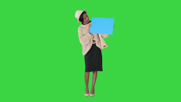 African American Woman Holding a Blank Placard on a Green Screen, Chroma Key