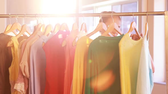 Woman selecting clothes from clothing rack