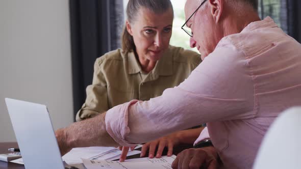 Caucasian senior couple with laptop calculating finances together at home